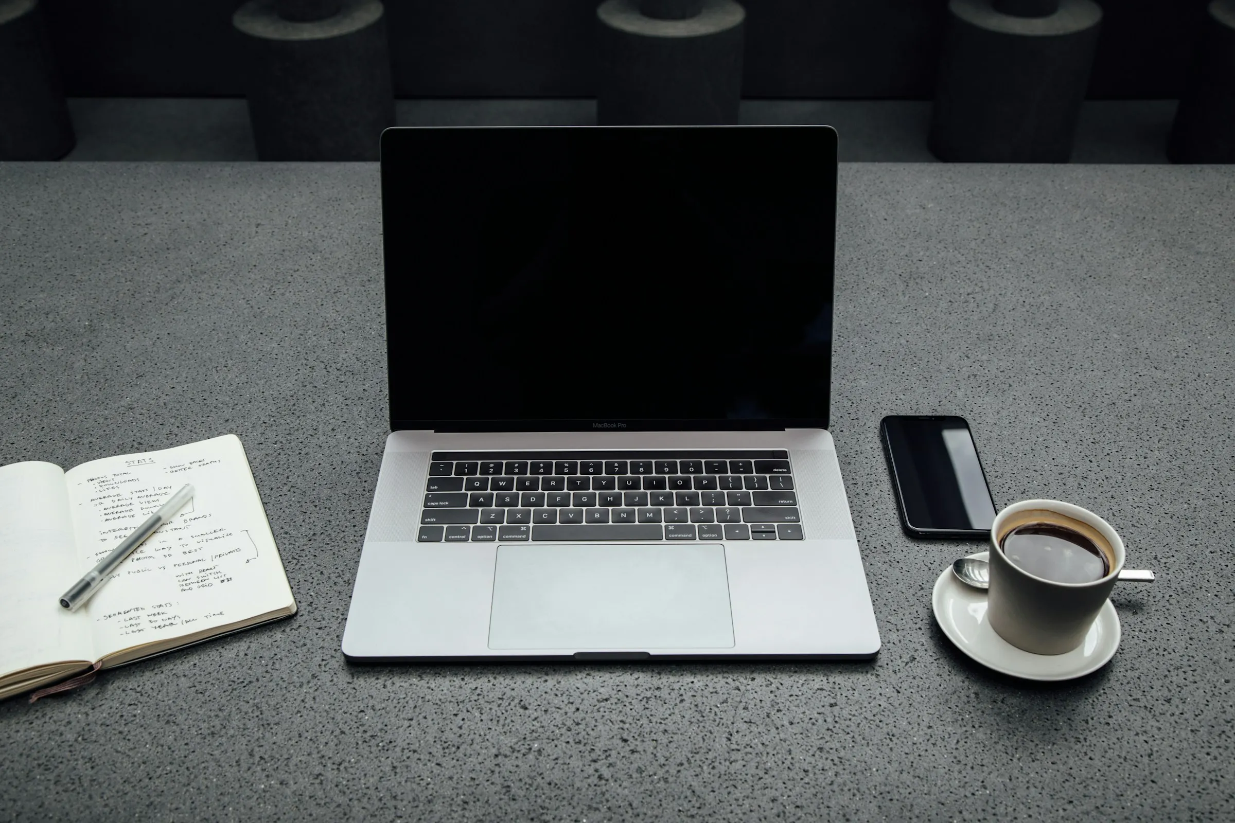 Laptop, telefon i notes z listą zadań na biurku.